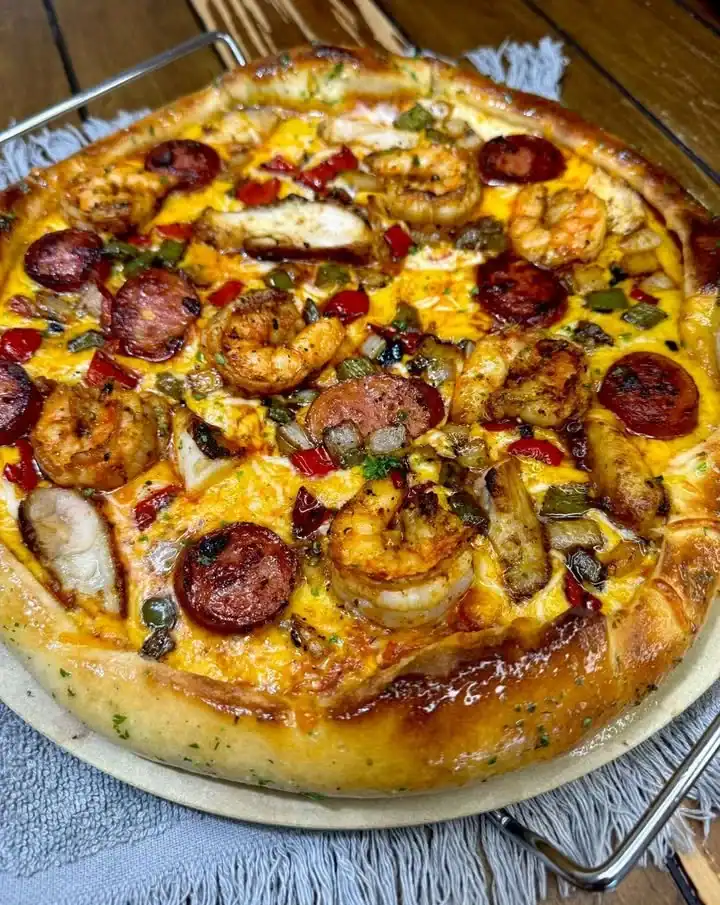 Cajun shrimp dish with sausage and smoked chicken, showcasing vibrant flavors and spices.