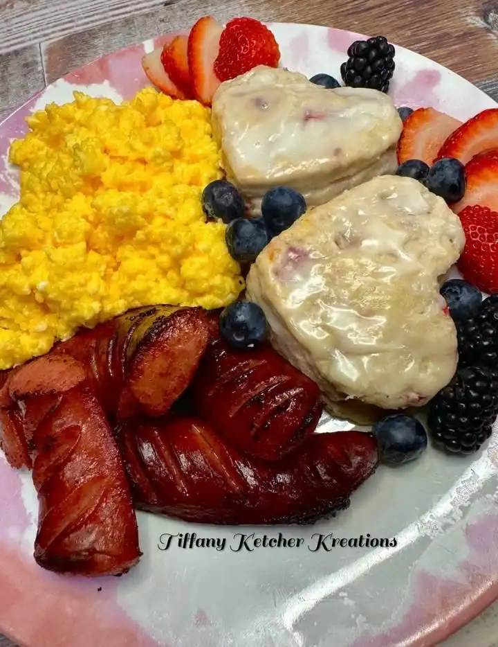 Cheesy scrambled eggs served with glazed strawberry buttermilk biscuits.