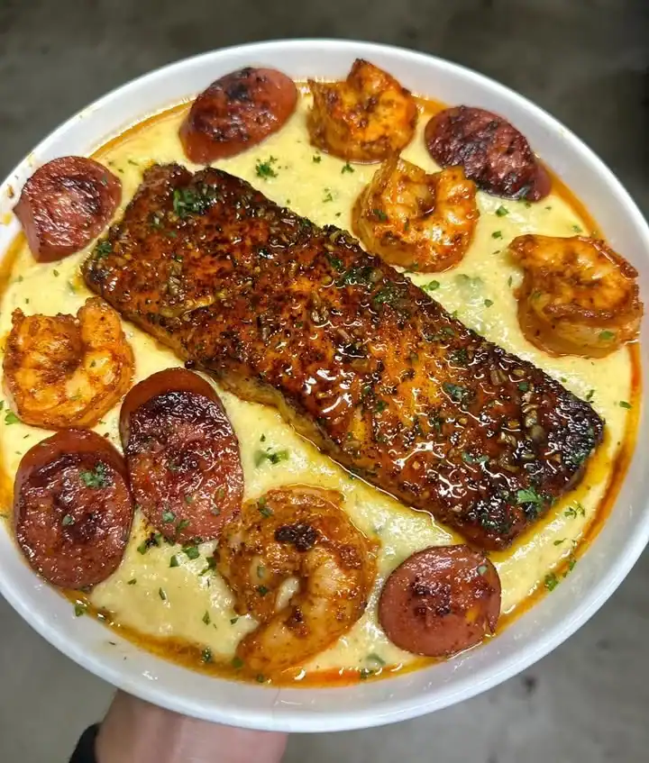 Salmon shrimp sausage dish over creamy jalapeno cheddar grits